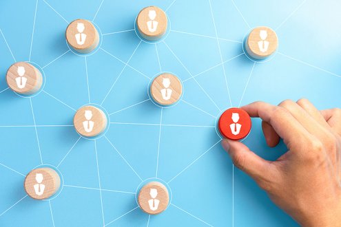 Netzwerk aus Holzscheiben mit Personen-Symbolen, eine Scheibe wird hervorgehoben.