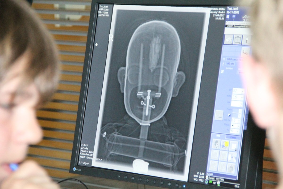 Röntgenbild einer Puppe auf Monitor, Kind betrachtet es neugierig.