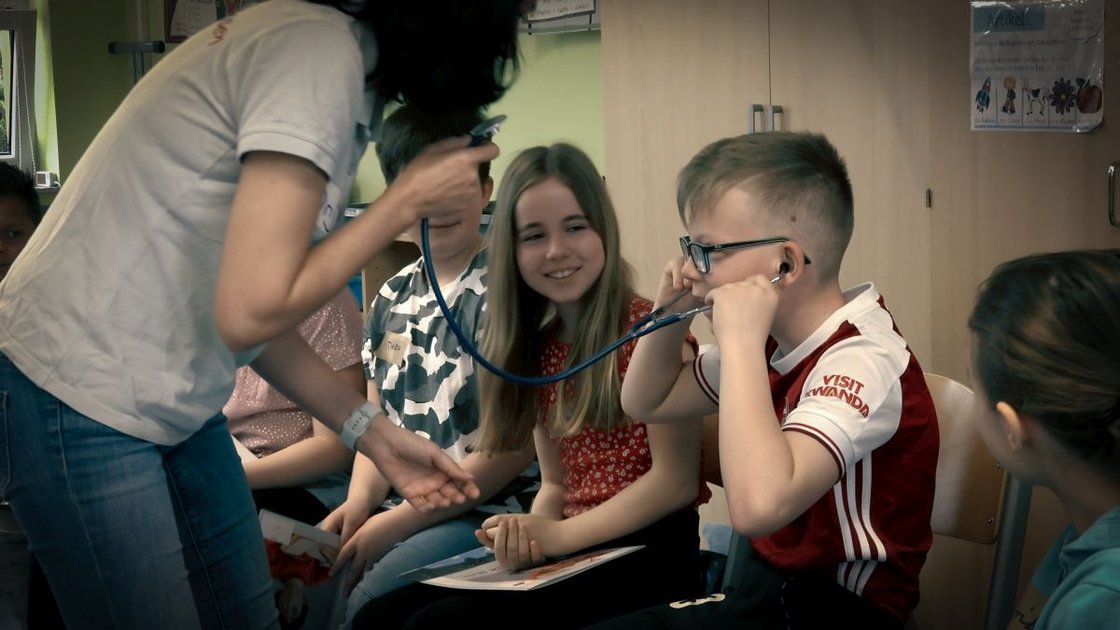 Kinder lernen mit Stethoskop im Bildungsprojekt Jonas will's wissen.