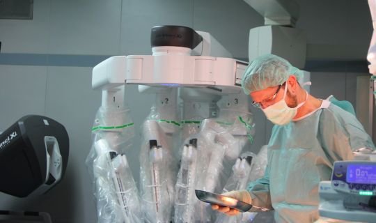 Chirurg arbeitet mit roboterassistierter Technologie im Operationssaal, symbolisiert moderne Chirurgie.