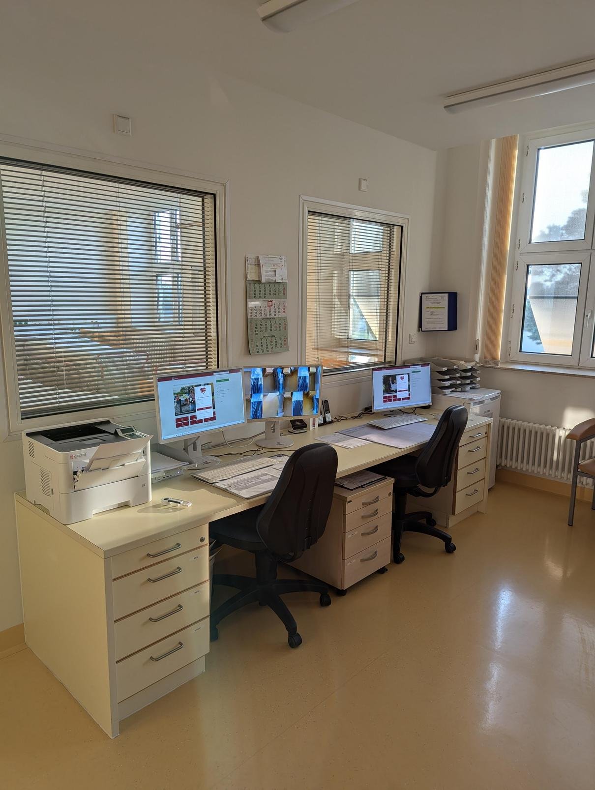 Moderner Büroarbeitsplatz im Ambulanten OP-Zentrum Halle-Dölau mit Computern und Drucker.