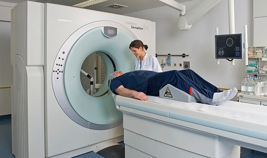 Medizinerin bereitet Patient auf CT-Scan im Radiologie-Institut vor.