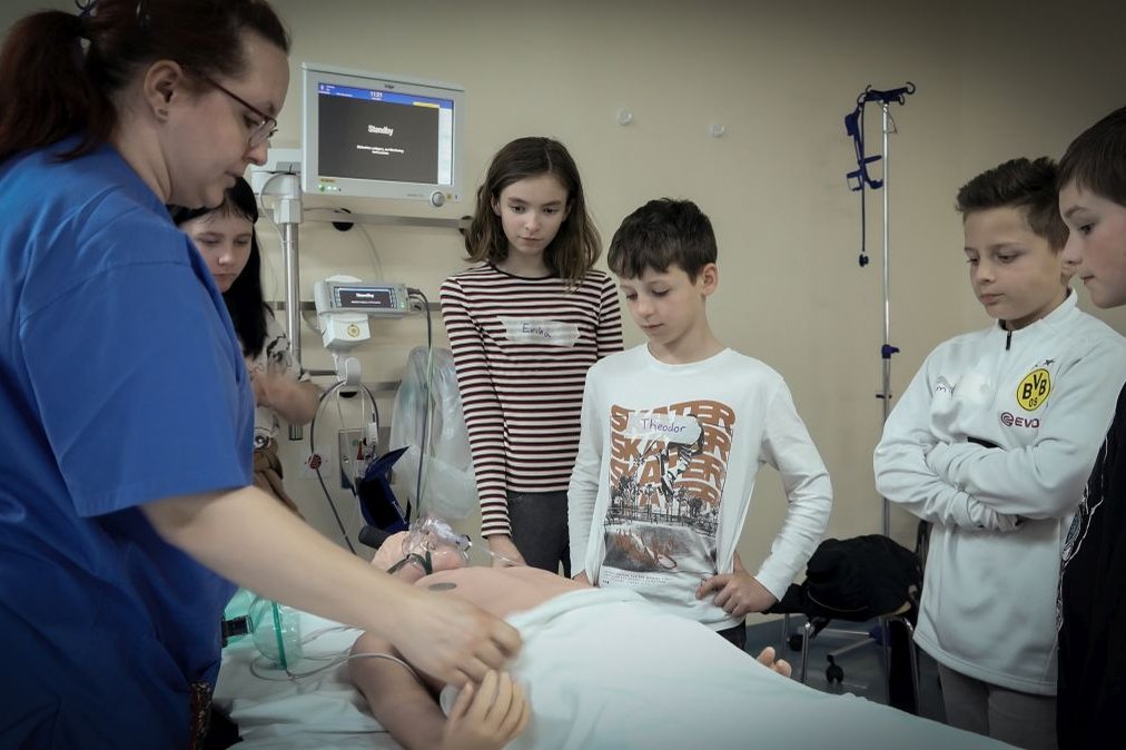 Kindergruppe beobachtet Krankenschwester bei Demonstration im Krankenhaus Martha-Maria.