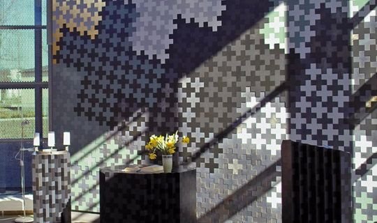 Moderne Kapelle mit Kreuzmustern und Blumenarrangement auf dem Altar.