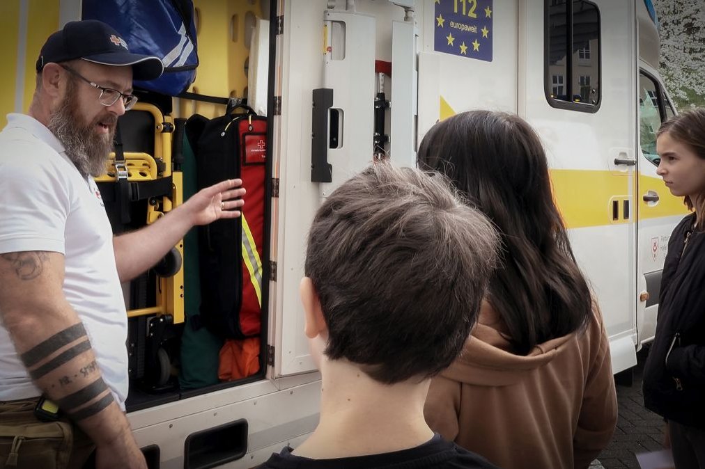 Sanitäter erklärt Kindern Krankenwagenausrüstung während des Projekts Jonas will's wissen.