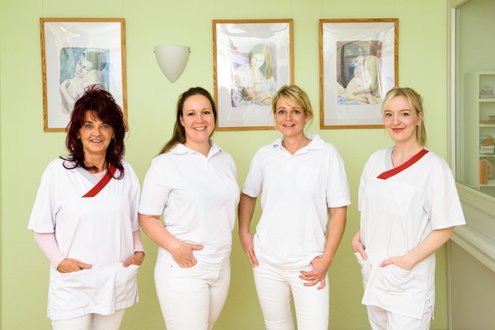 Vier Mitarbeiterinnen der Gynäkologie in weißen Kitteln lächeln in die Kamera.